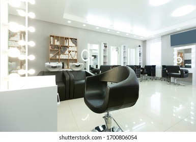 Barber chair and backlit mirror in bright Interior, free space