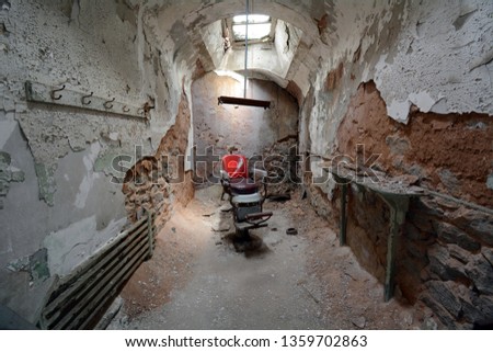 Barber Chair Under a Skylight in an Old Abandoned Stone Prison Cell