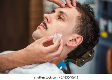 Barber Closing Mans Pores With Alum Stone. Traditional Ritual Of After Shaving The Beard With Alum Stone. Client Getting His Face Rubbed With Alum Stone After Shaving In Barber Shop