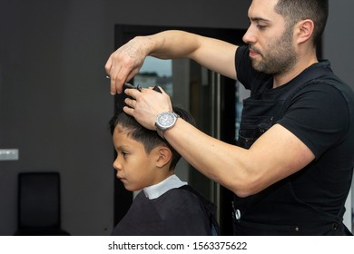 Barber Cuts Hair To A Child In The Barber Shop