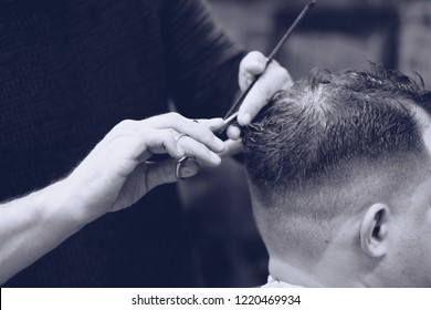barber cuts a man with scissors.