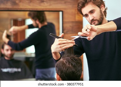 barber cutting hair with scissors. back view of man in barber shop. 