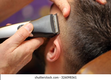 Barber cutting and modeling hair by electric trimmer - Powered by Shutterstock