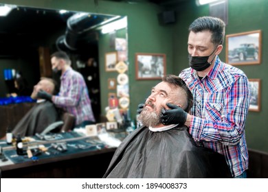 Barber Gives A Beard Massage To An Older Man In A Barbershop