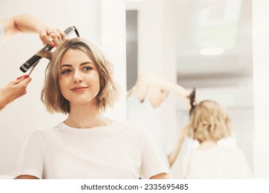 Barber salon. Customer service in barbershop room, create making hairdress. Hairdresser lady curling hairstyle for lovely young woman in hair salon. Concept of hairstyle, lifestyle. Copy ad text space - Powered by Shutterstock