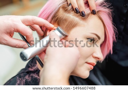 Image, Stock Photo Barber shaves the temple with cordless trimmer during a short haircut on the sides of the head.