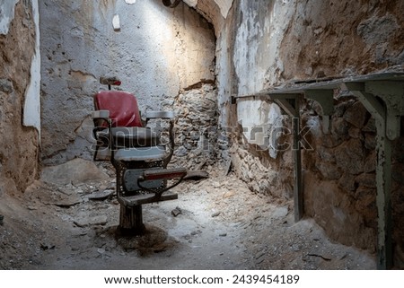 A barber shop chair in a crumbling cell room in the Eastern State Penitentionry of Philadelphia.