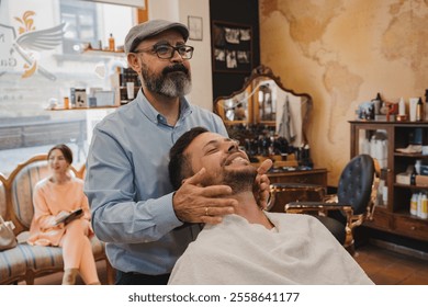 barber shop concept and people - Barber applying aftershave to a man's face in a barber shop - Powered by Shutterstock