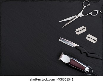 Barber shop equipment on Black background with place for text.  Professional hairdressing tools. Comb, scissor, clippers and hair trimmer isolated. 