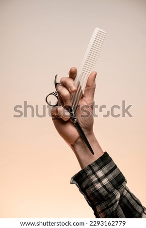 Barber shop. Barber or hairdresser male hand holding scissors and comb. Barber professional tools. Male haircut, fashion.