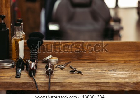 barber tools on wooden shelf and mirror in barbershop