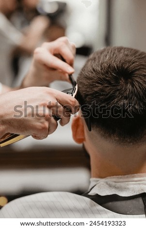 Similar – Image, Stock Photo Barber shaves the temple with cordless trimmer during a short haircut on the sides of the head.