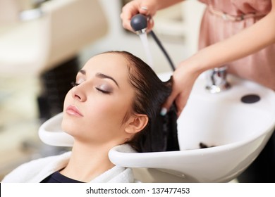 Barber washes the girl's head in the barbershop - Powered by Shutterstock