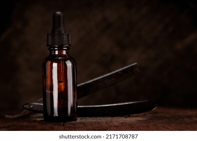 Barbershop Concept. Barber Tools, Razor And Bottle Of Beard Oil On Dark Wooden Background.