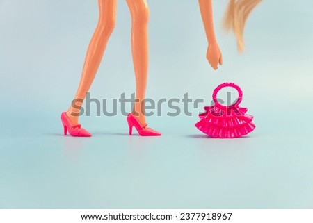 Barbie doll in a pink dress on a blue background. various accessories for playing with a doll.