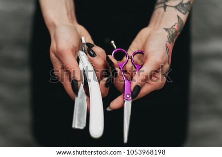 Barbie girl in a tattoo that holds dangerous scissors and a razor in her arms