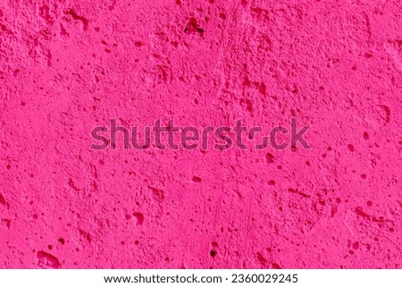 Barbie pink tones textured concrete wall with space for text