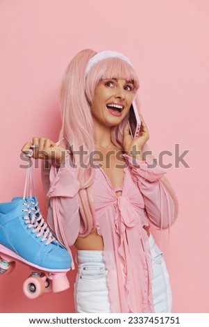 Barbie style girl in pink clothes and with long pink hair talking on phone and holding blue oller-skates in hand, Barbie doll style concept, copy space