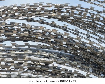 Barbwire on sky background. Barbwire fastened with metal clamps. Steel fence with spikes. Steel barbed fence. Barbwire sale and installation concept. Metal fence for boundary. Protective barrier