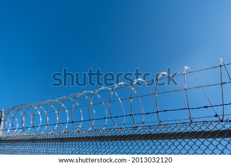 barbwire prison wall with barbed wire fence coiled razor wire perimeter fence, barbed fence.