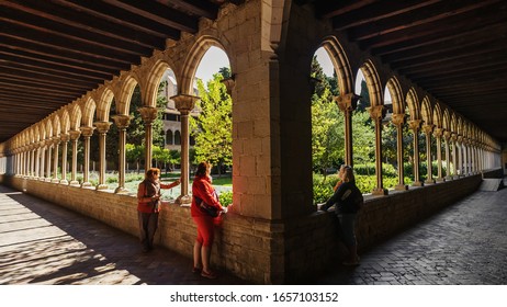 Barcelona, Catalonia/Spain-March 27, 2019: Monastery of Pedralbes. The first floor of the cloister. Three girls look through the arches at the inner garden. 