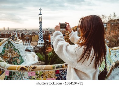 Barcelona signature style. modern tourist woman in coat at Guell Park in Barcelona, Spain looking into the distance