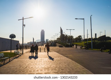 Barcelona, Spain - 05.12.2018: Beautiful Sunny Day With People Cycling And Walking Along A Street Close To The Beach