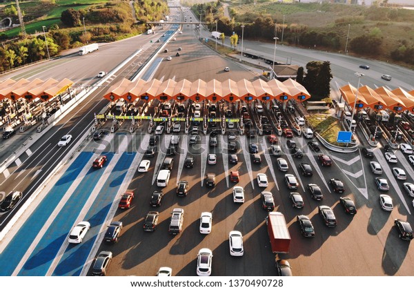 Barcelona / Spain 14 04 2019: Aerial\
or drone shot of an overloaded toll road or tollway on the\
controlled-access highway at the sunset. Forced traffic jam\
concept.