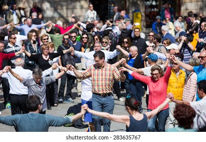 BARCELONA, SPAIN - APRIL 5, 2015: People Dancing Circle Dance Long Sardana At Ballades Al Pla De La Catedral Holiday.