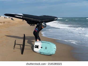 Barcelona, Spain - April 8, 2022: Middle-aged woman ready to start practicing wing foil, fashionable sport on the beaches, adrenaline and ecology guaranteed.