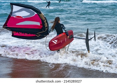 Barcelona, Spain - April 8, 2022: Young girl ready to start practicing wing foil, fashionable sport on the beaches, adrenaline and ecology guaranteed.
