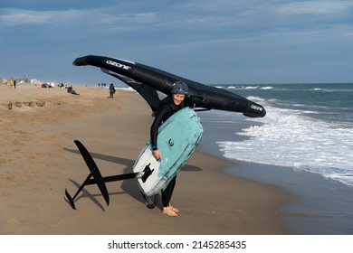 Barcelona, Spain - April 8, 2022: Middle-aged woman ready to start practicing wing foil, fashionable sport on the beaches, adrenaline and ecology guaranteed