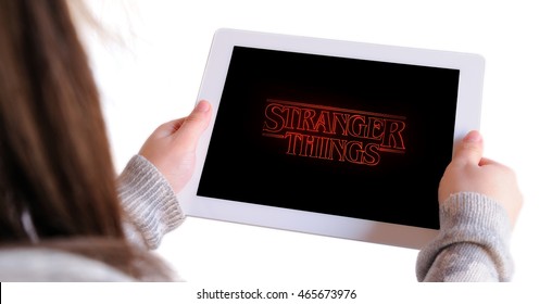 BARCELONA, SPAIN - AUG 8, 2016: Unrecognizable woman watching Stranger Things, a science fiction horror web television series released on Netflix, on an Apple Ipad, isolated on white background.