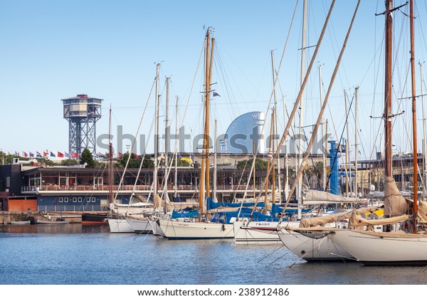 Barcelona, Spain - August 26, 2014: Vista port\
landscape with Montjuic cable car tower. Yachts and sailing boats\
are moored in marina