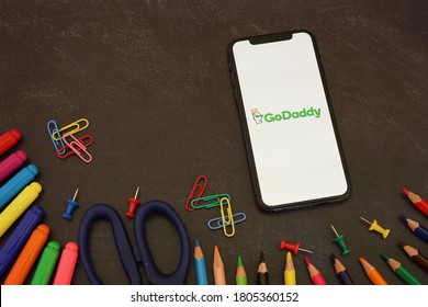 Barcelona, Spain - August 30, 2020; GoDaddy App with Colored Pencils and Blue Scissor. GoDaddy is an Internet domain registrar and web hosting company. #GoDaddy