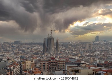 Barcelona, Spain - Feb 24, 2020: Sagrada Familia In The Eye Of Storm Cloud With Sunbeam Through Overcast