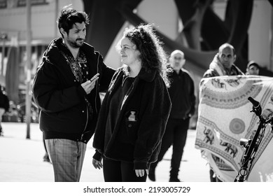 BARCELONA, SPAIN - FEBRUARY 20, 2022: A Smiling Couple Walks Near The City's Urban Beach.