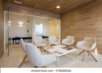 Barcelona / Spain - February 2020:  Elegant waiting room. White chairs and glass wall in a wooden room.