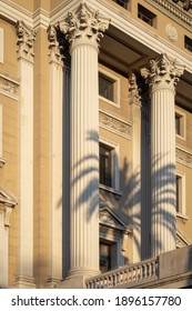 Barcelona, Spain - January 15, 2021: Corinthian Order Columns On A Historical Building In The Old Town Of Barcelona. Sunlight And Plam Tree Shadow.