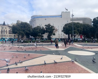 Barcelona, Spain - January 28, 2022; Tourists visiting Catalonia square crowded with pigeons in Barcelona