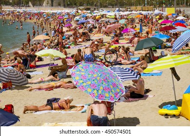 BARCELONA, SPAIN - JULY 10: People sunbathing at Nova Icaria Beach on July 10, 2016 in Barcelona, Spain. This busy beach is mainly frequented by the locals