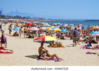 BARCELONA, SPAIN - JULY 10: Sunbathers at Platja del Bogatell beach on July 10, 2016 in Barcelona, Spain, with the Parc del Forum in the background. This busy beach is mainly frequented by the locals