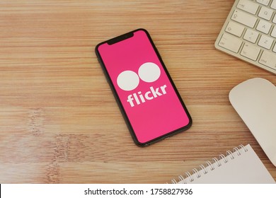 Barcelona, Spain - June 18, 2020; Flickr Iphone Screen with Keyboard Mouse on a Bamboo Table. Flickr is an image hosting service and video hosting service. #Flickr
