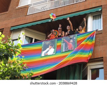 Barcelona, Spain, June 28th 2009: Four happy gay men waving from a balcony with a large gay flag and photos of Michael Jackson