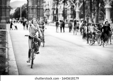 Barcelona, Spain - May 13 2014: Cheerful Girl Crossing The Promenade Passeig De Lluís Companys On A Shared Bike.