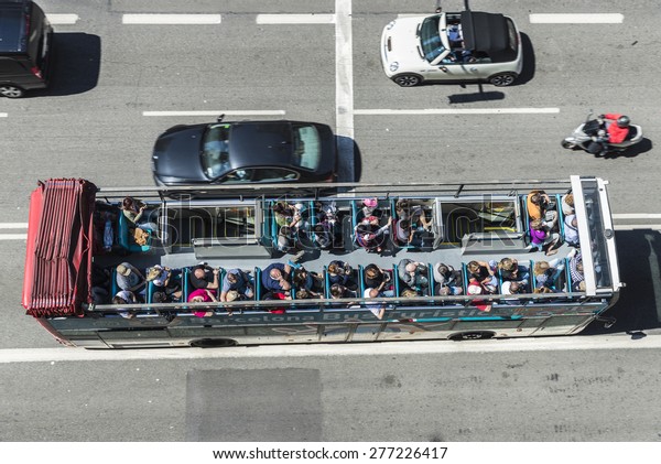 Barcelona, Spain - May 2,\
2015: Aerial view of a tourist bus in motion. Barcelona City Tour\
is an official touristic bus service that shows the city with an\
audio guide.
