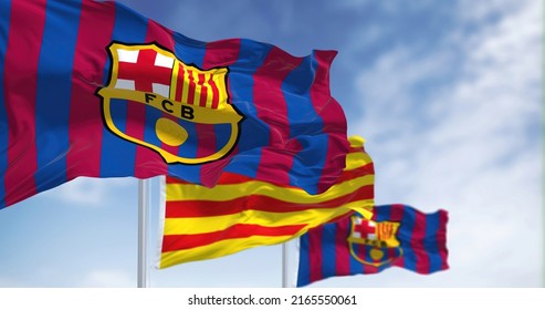 Barcelona, Spain, May 2022: Two Flags Of FC Barcelona Are Waving In The Wind With The Catalonia Flag In The Middle
