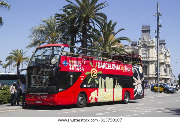 Barcelona, Spain - May 22, 2015: Tourists get on a\
double decker tour bus for an excursion in the harbor area of\
Barcelona, Spain on May 22,\
2015.