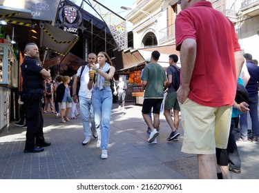 Barcelona, Spain - May 26, 2022: Security Person With A Radical Haircut, Watches Attentively With His Arms Crossed At The Entrance Of The Boqueria Market, A Typical Place For Tourists. 