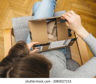 Barcelona, Spain - Nov 4, 2017: Overhead view of curious woman unboxing in the living room new Amazon Prime Parcel delivery of e-commerce ordered goods via internet
